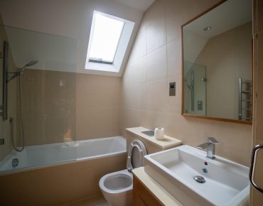 modern bathroom with grey tails and white ceiling painted by house painters london